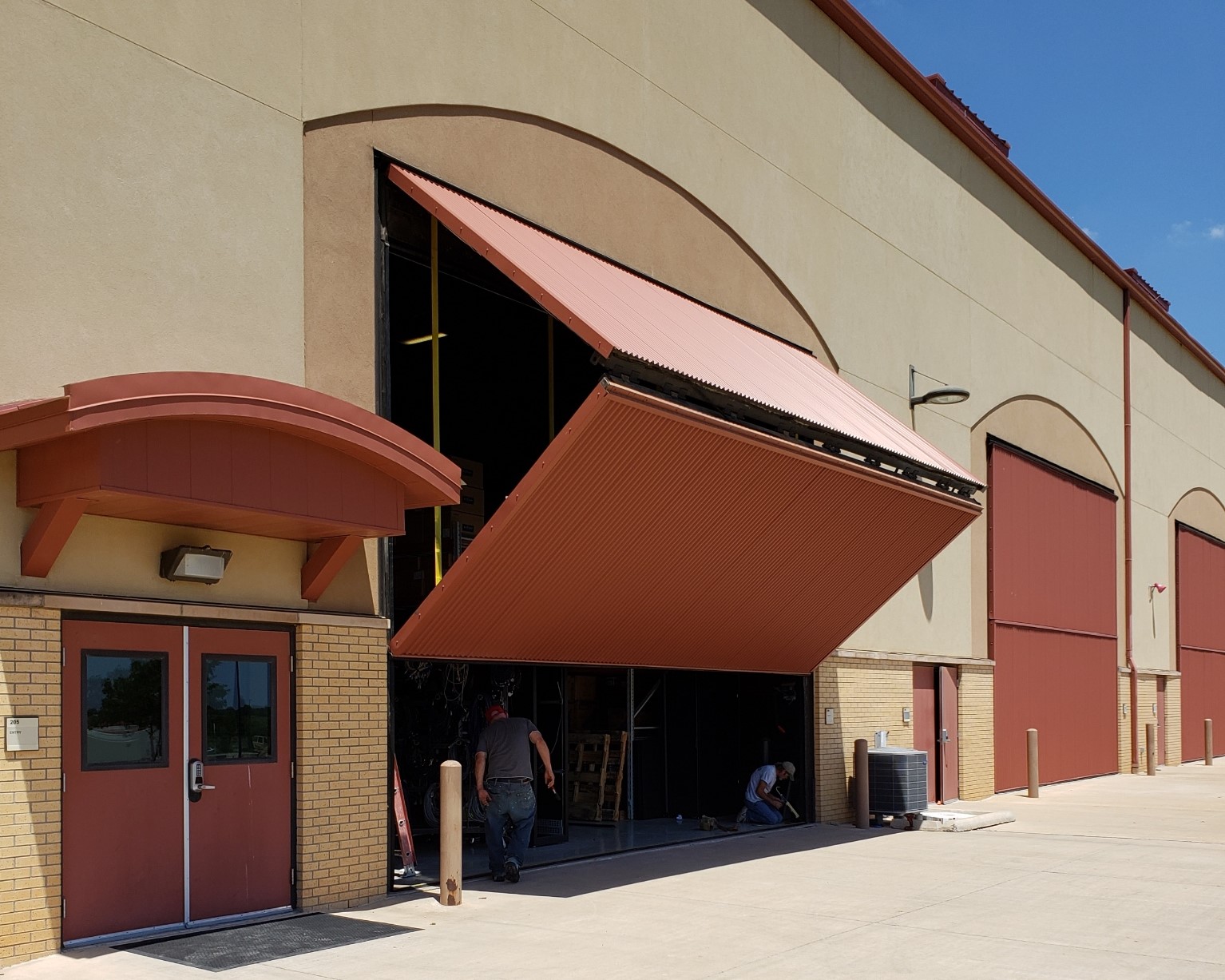 Large hydraulic hangar-style door installed on a maintenance facility in Southwest Oklahoma